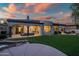 Expansive backyard view with covered patio, green turf, and a serene water feature at 7775 E Fledgling Dr, Scottsdale, AZ 85255