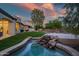 An immaculate backyard showcasing a rock water feature and artificial turf at 7775 E Fledgling Dr, Scottsdale, AZ 85255