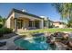 Beautiful backyard boasts lush lawn, luxurious outdoor living, and a serene spa with natural rock waterfall at 7775 E Fledgling Dr, Scottsdale, AZ 85255