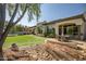 Beautiful home exterior and patio surrounded by manicured artificial grass and mature desert landscaping at 7775 E Fledgling Dr, Scottsdale, AZ 85255