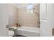 Bathroom with tub, tile surround, and decorative recessed window for natural light at 7775 E Fledgling Dr, Scottsdale, AZ 85255