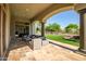 An elegant covered patio extends living space outdoors with views of the lush, manicured backyard at 7775 E Fledgling Dr, Scottsdale, AZ 85255