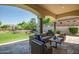 Spacious covered patio offers ample seating overlooking the manicured backyard and serene water feature at 7775 E Fledgling Dr, Scottsdale, AZ 85255