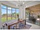 Open dining area with backyard view, statement lighting, and sleek tile floors at 7775 E Fledgling Dr, Scottsdale, AZ 85255
