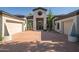 Front exterior displaying the desert landscaping and dual garage doors on both sides of the entrance at 7775 E Fledgling Dr, Scottsdale, AZ 85255