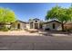 Daytime exterior showing the property's circular design and symmetrical landscaping with desert foliage at 7775 E Fledgling Dr, Scottsdale, AZ 85255