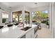 Modern kitchen with white cabinets, stainless steel appliances, island, and large windows providing ample natural light at 7775 E Fledgling Dr, Scottsdale, AZ 85255