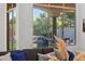 Sunlit living room featuring large windows overlooking a serene outdoor lounge area with stone accents at 7775 E Fledgling Dr, Scottsdale, AZ 85255
