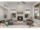 Inviting living room featuring a fireplace, neutral-toned furniture, a ceiling fan, and natural light at 7775 E Fledgling Dr, Scottsdale, AZ 85255