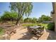 Outdoor dining area on a stone patio, complemented by a lush lawn and desert landscaping at 7775 E Fledgling Dr, Scottsdale, AZ 85255