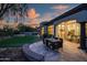 Covered patio features an outdoor dining area overlooking lush backyard and tranquil water feature at 7775 E Fledgling Dr, Scottsdale, AZ 85255