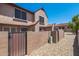 Exterior view of a backyard featuring a low block fence, a gate, and desert landscaping with rock ground cover at 8111 W Wacker Rd # 94, Peoria, AZ 85381