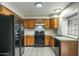 A kitchen with wooden cabinets, black appliances, and tile flooring at 8111 W Wacker Rd # 94, Peoria, AZ 85381