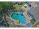 Aerial view of sparkling backyard pool with colorful umbrellas and patio furniture, great for relaxation and entertaining at 927 N Somerset Cir, Mesa, AZ 85205