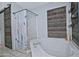 Cozy bathroom featuring a large soaking tub, glass shower, and rustic sliding barn door at 927 N Somerset Cir, Mesa, AZ 85205