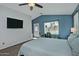 Comfortable bedroom featuring plush carpet flooring, a ceiling fan, and large windows offering natural light at 927 N Somerset Cir, Mesa, AZ 85205