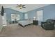 Comfortable bedroom featuring plush carpet flooring, a ceiling fan, and large windows offering natural light at 927 N Somerset Cir, Mesa, AZ 85205