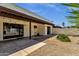 Private backyard with a covered patio, gravel landscaping, and mature greenery at 9322 E Jenan Dr, Scottsdale, AZ 85260