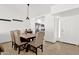Bright dining area with a wooden table, upholstered chairs, neutral tile floor, and view into the kitchen at 9322 E Jenan Dr, Scottsdale, AZ 85260