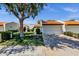 Charming single-story home with a well-manicured lawn, mature shade tree, and a two-car garage with a red tile roof at 9322 E Jenan Dr, Scottsdale, AZ 85260