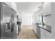 Well-lit kitchen featuring stainless steel appliances, white cabinets, tile backsplash, and neutral flooring at 9322 E Jenan Dr, Scottsdale, AZ 85260