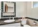 Bathroom featuring countertop with dark marbled design and decorative mirror at 1004 E Gemini Dr, Tempe, AZ 85283