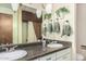 Bathroom featuring a dual sink vanity with decorative greenery and tiled floors at 1004 E Gemini Dr, Tempe, AZ 85283
