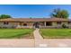 Beautiful brick home with lush green lawn and inviting arched entry at 1004 E Gemini Dr, Tempe, AZ 85283