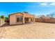 View of the backyard with a patio, lush trees, and blue skies at 10934 W Almeria Rd, Avondale, AZ 85392