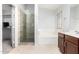 Bathroom with a glass-enclosed shower, soaking tub, single sink vanity and closet access at 10934 W Almeria Rd, Avondale, AZ 85392