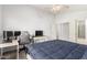 Bedroom with a gaming setup and en-suite bathroom featuring a walk-in closet at 10934 W Almeria Rd, Avondale, AZ 85392