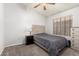 Cozy bedroom with carpeted floors, window, a ceiling fan and a dresser at 10934 W Almeria Rd, Avondale, AZ 85392