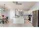 Open kitchen with granite countertops, stainless steel appliances, and dining area at 10934 W Almeria Rd, Avondale, AZ 85392