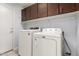 Laundry room with white washer and dryer and plenty of cabinet storage at 10934 W Almeria Rd, Avondale, AZ 85392