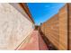 Side yard access with brick-lined walkway and decorative block wall at 10934 W Almeria Rd, Avondale, AZ 85392