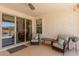 Back patio with two chairs, decorative pillows and outdoor access through sliding glass door at 1166 W Silver Creek Ln, Queen Creek, AZ 85140