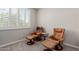 Bright bedroom nook with lounge chairs, footrests, and neutral-toned walls at 1166 W Silver Creek Ln, Queen Creek, AZ 85140