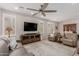 Bright, open-concept living room featuring wood floors, a ceiling fan, and ample natural light at 1166 W Silver Creek Ln, Queen Creek, AZ 85140
