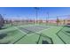 Outdoor pickleball court with lighting, surrounded by fencing, perfect for recreational play and community engagement at 1166 W Silver Creek Ln, Queen Creek, AZ 85140