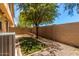 A fenced backyard with a patio, gravel, small patch of grass, and desert landscaping at 1250 S Rialto -- # 78, Mesa, AZ 85209