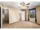 A carpeted bedroom with a ceiling fan, a window, and doors to the bathroom and closet at 1250 S Rialto -- # 78, Mesa, AZ 85209