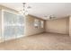 Bright living room featuring neutral carpeting, ceiling fan, and large sliding glass door at 1250 S Rialto -- # 78, Mesa, AZ 85209