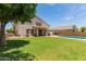 Expansive backyard view featuring a lush lawn, patio, and swimming pool, perfect for outdoor enjoyment at 14099 W Riviera Dr, Surprise, AZ 85379