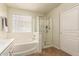 This bathroom boasts a clear glass shower, a tub, and natural light from the glass block window at 14099 W Riviera Dr, Surprise, AZ 85379
