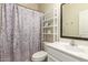 Well-lit bathroom featuring a vanity, toilet, and shower with patterned curtain at 14099 W Riviera Dr, Surprise, AZ 85379