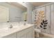 Bathroom features double vanity sinks with framed mirror and a stylish floral shower curtain at 14099 W Riviera Dr, Surprise, AZ 85379