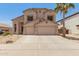 Two-story home with a neutral color palette, a two-car garage, and desert landscaping in the front yard at 14099 W Riviera Dr, Surprise, AZ 85379