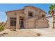 Two-story home with a neutral color palette, a two-car garage, and desert landscaping in the front yard at 14099 W Riviera Dr, Surprise, AZ 85379