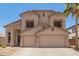 Two-story home with a neutral color palette, a two-car garage, and desert landscaping in the front yard at 14099 W Riviera Dr, Surprise, AZ 85379