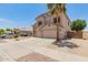 Two-story home with a neutral color palette, a two-car garage, and desert landscaping in the front yard at 14099 W Riviera Dr, Surprise, AZ 85379